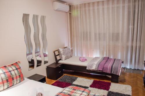 Habitación con cama, silla y ventana en Apartment Bohemian Rhapsody, en Belgrado