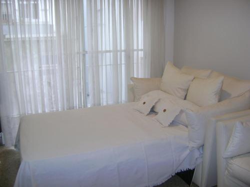 a white bed with white pillows in a bedroom at Departamento Pedro Luro in Mar del Plata