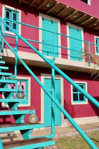 a colorful building with blue stairs and windows at The Upcycled Hostel Huacachina in Ica