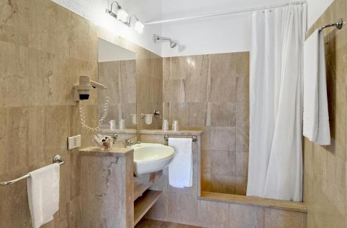 a bathroom with a sink and a shower at Colonna Palace Hotel Mediterraneo in Olbia