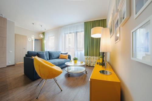 a living room with a blue couch and a table at Sopocka Rezydencja, Sun & Snow in Sopot