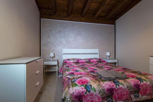 ポルト・エンペードクレにあるB&B Villa Marikaのベッドルーム1室(ピンクの花が咲く大型ベッド1台付)