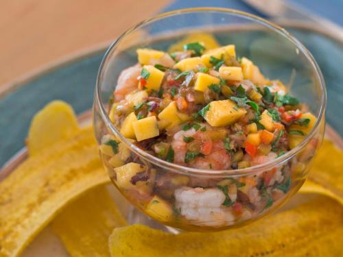 a glass bowl of salsa on a plate with a banana at GHL Relax Hotel Costa Azul in Santa Marta
