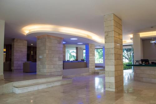 a lobby with columns in a building at GHL Relax Hotel Costa Azul in Santa Marta