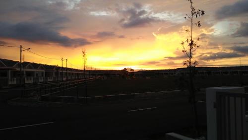 a sunset with the sun setting in the sky at MaiHomestay Seri Iskandar in Seri Iskandar