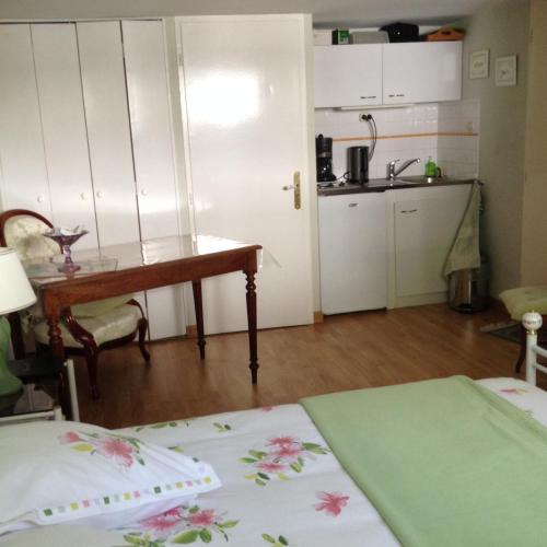 une chambre avec deux lits, une table et une cuisine dans l'établissement Agora Mijo Chambre d'Hôtes, à Nantes