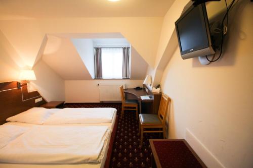 a hotel room with two beds and a tv at Hotel-Gasthof Obermeier in Allershausen