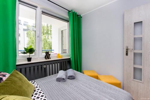 Schlafzimmer mit grünen Vorhängen, einem Bett und einem Fenster in der Unterkunft ClickTheFlat Hoża Street Apart Rooms in Warschau