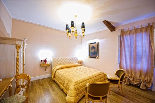 1 dormitorio con cama y lámpara de araña en Boutique Hotel L'Imperatrice, en Foiano della Chiana