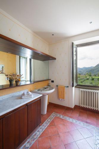 a bathroom with a tub and a sink and a window at Olea Dei Holiday Apartments in San Felice del Benaco