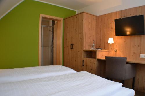 a bedroom with a white bed and a green wall at Brigel-Hof in Meßkirch