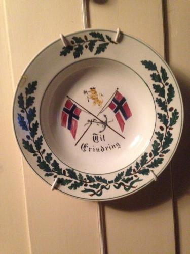 a plate on a wall with two flags on it at Ivaregga Vinterstua in Tolga