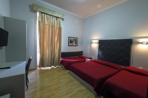 a bedroom with a red bed and a couch at Hotel d'Este in Rome