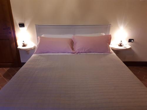 a white bed with two lights on two tables at Il Gelso Room&breakfast in Pennabilli