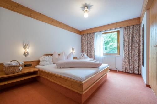 ein Schlafzimmer mit einem Bett in einem Zimmer mit einem Fenster in der Unterkunft Haus Montana in Elbigenalp