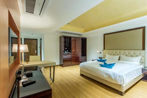 乌贾因Hotel Abika Elite的一间带床和书桌的酒店房间