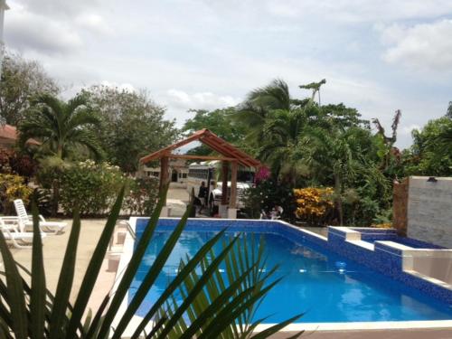 a blue swimming pool with a gazebo in a yard at Casa Loma in Pedasí Town