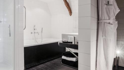 a white bathroom with a shower and a sink at Château Les Merles et ses Villas in Mouleydier