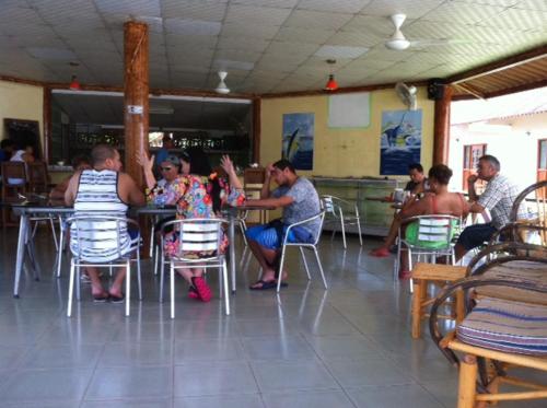 a group of people sitting at a table in a restaurant at Casa Loma in Pedasí Town