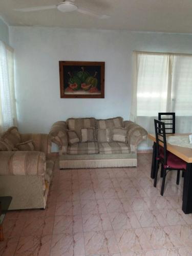 a living room with a couch and a table at Room in Cancun Stadium in Cancún