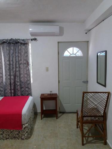 a bedroom with a bed and a chair and a door at Room in Cancun Stadium in Cancún