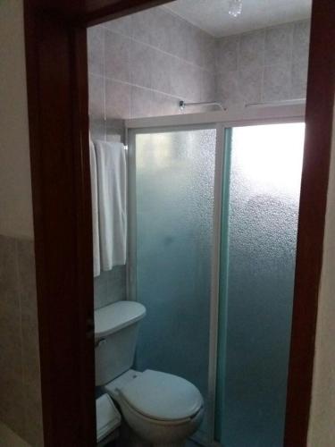 a bathroom with a toilet and a glass shower at Room in Cancun Stadium in Cancún