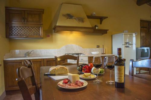 a table with two glasses of wine and food on it at Agriturismo Le Gallozzole in Monteriggioni