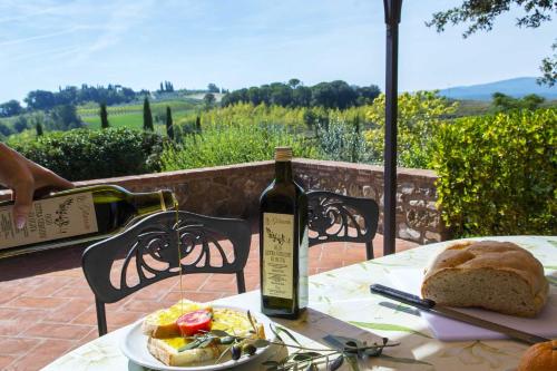 a bottle of wine sitting on a table with a plate of food at Agriturismo Le Gallozzole in Monteriggioni