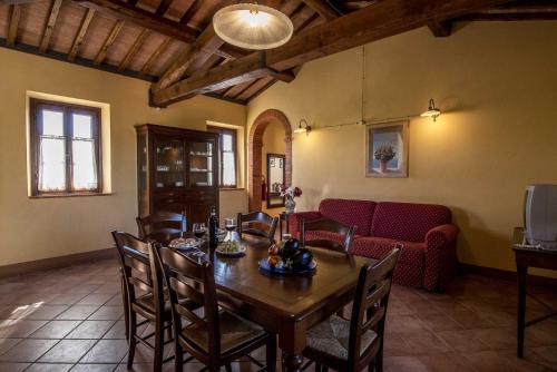 a dining room with a table and chairs and a couch at Agriturismo Le Gallozzole in Monteriggioni
