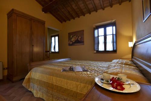 a bedroom with a bed with a plate of food on it at Agriturismo Le Gallozzole in Monteriggioni