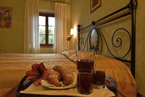 a tray with two drinks and pastries on a bed at Agriturismo Le Gallozzole in Monteriggioni