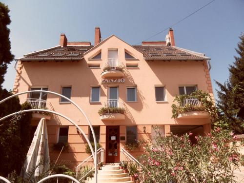 a large house with stairs in front of it at Kálmán Panzió in Szeged