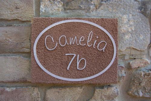 a sign that says comedia on a brick wall at Agriturismo Le Gallozzole in Monteriggioni