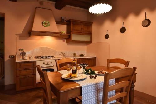 a kitchen with a table and chairs and a stove at Agriturismo Le Gallozzole in Monteriggioni
