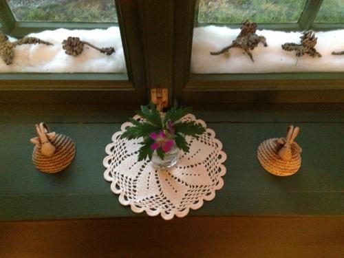 a table with a plate with a plant in a vase at Ivaregga Vinterstua in Tolga