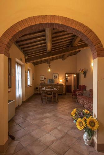 a living room with an archway and a table and chairs at Agriturismo Le Gallozzole in Monteriggioni