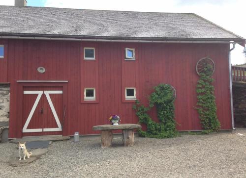 a red barn with a bench in front of it at Ivaregga Vinterstua in Tolga