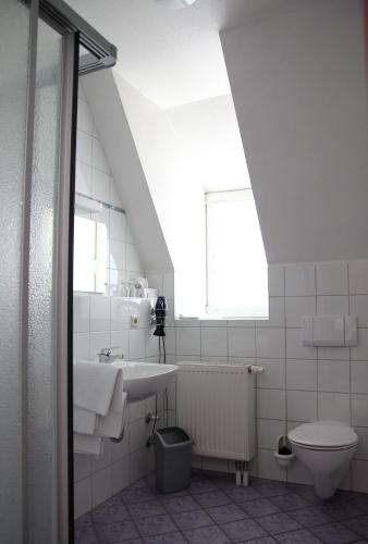 a bathroom with a sink and a toilet and a window at Gästehaus Zehntgraf in Wipfeld