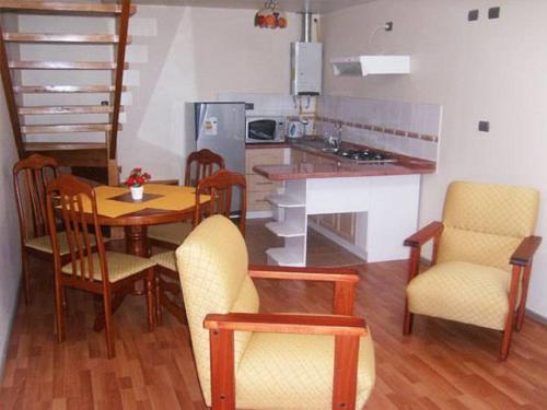 a kitchen with a table and chairs and a kitchen with a counter at Apart Hotel en Puerto Montt in Puerto Montt