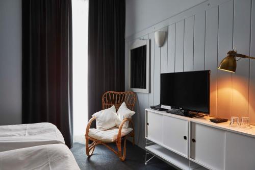 1 dormitorio con TV, silla y cama en Hotel Monterosa, en Alagna Valsesia