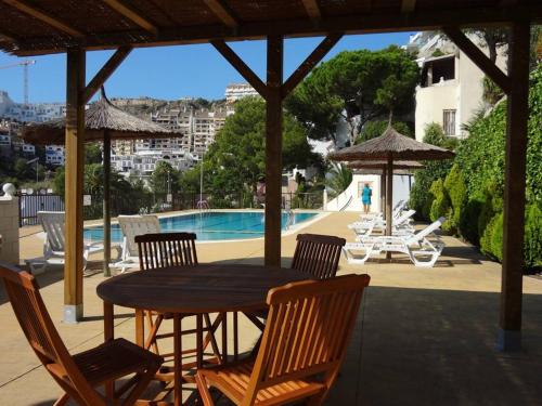 a patio with a table and chairs and a pool at Chalet Apartamento Manolo in Faro de Cullera