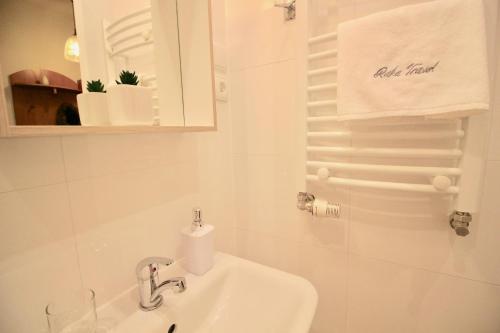 Baño blanco con lavabo y espejo en Apartament Bazatatry Kościeliska, en Zakopane