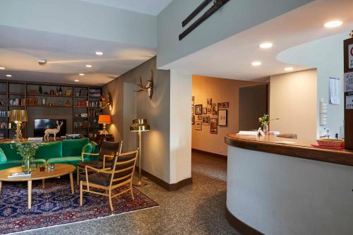 a lobby with a bar and a green couch at Hotel Monterosa in Alagna Valsesia