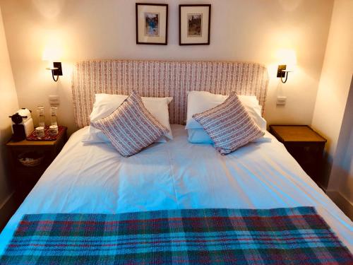 a bed with a blue comforter and two pillows at The Dorset Arms Pub & Cottage Rooms in Groombridge