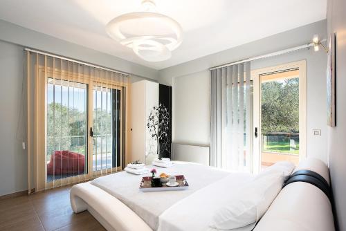 コルフ・タウンにあるGirasole Villaの白いベッドルーム(大型ベッド1台、大きな窓付)