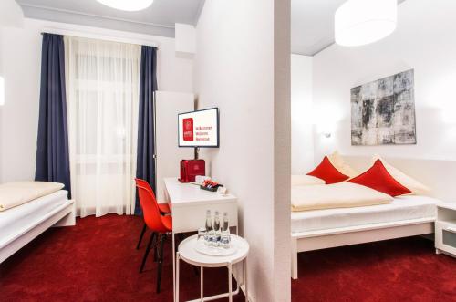 a hotel room with two beds and a table at Hotel Mille Stelle City in Heidelberg