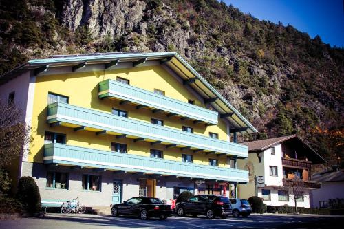 a yellow building with cars parked in front of it at Gasthof Schaber in Pettnau