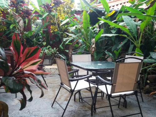 a table and chairs in a garden with plants at Punta Duarte Garden Inn in Los Duarte