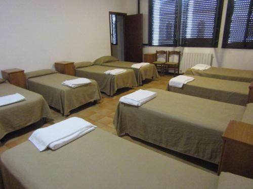 a room with four beds with towels on them at Monastero San Vincenzo - Casa Per Ferie in Bassano Romano