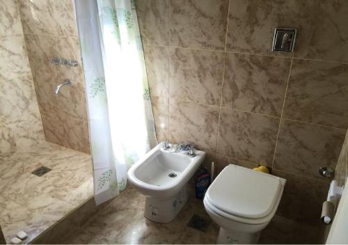 un baño con inodoro y lavabo en La Casita de Thor, en Monte Hermoso